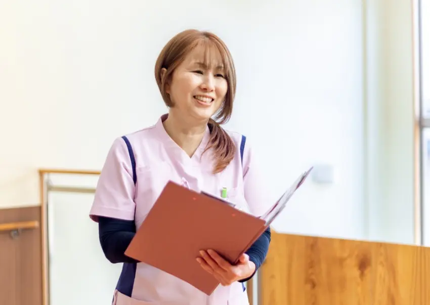 書類を持って説明を行う職員F.R.さんの様子