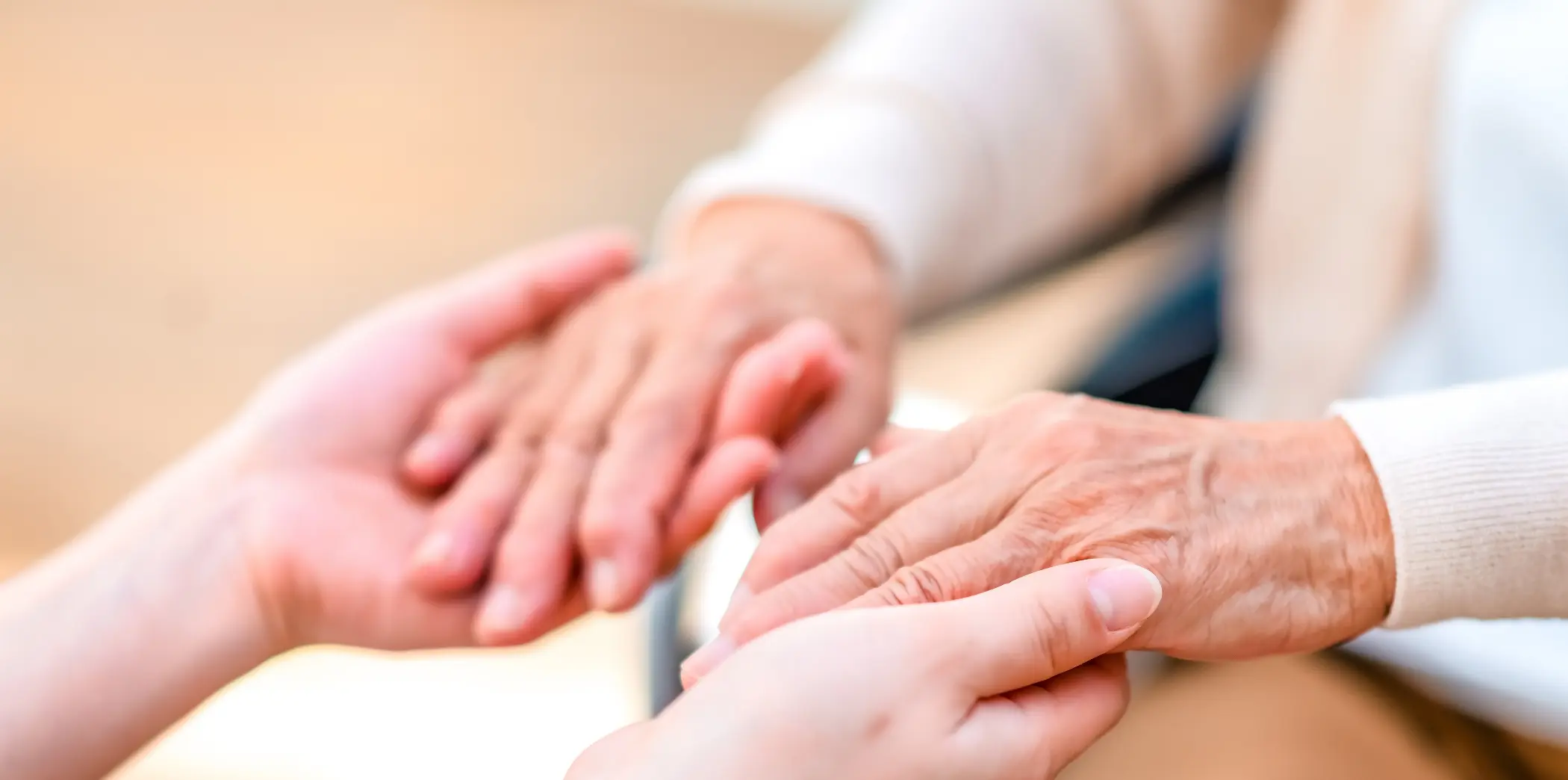 利用者の手をやさしく支える介護スタッフの手元