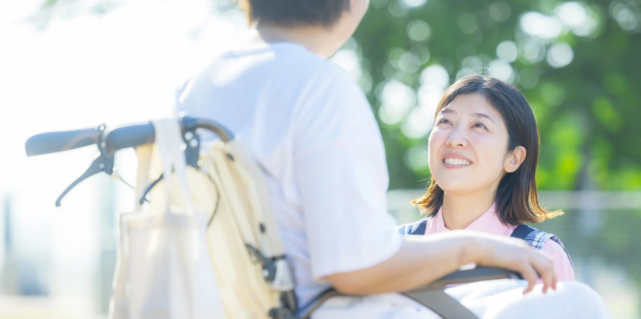 車椅子を利用する方に笑顔で寄り添う介護スタッフの様子